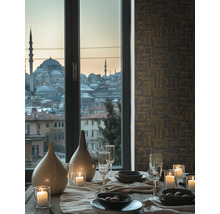 Dekoratívny jedálenský stôl s riadom, pohármi, sviečkami a vázami pred oknom s výhľadom na mesto.