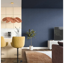 Obývacia izba s modrou tapetou, barovými stoličkami a izbovou rastlinou