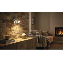 Obývacia izba s murovanou stenou, komodou a dvojramenným nástenným svietidlom