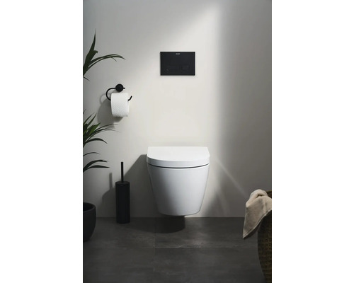 Závesné WC v kúpeľni s ovládacím panelom, držiakom toaletného papiera a rastlinami