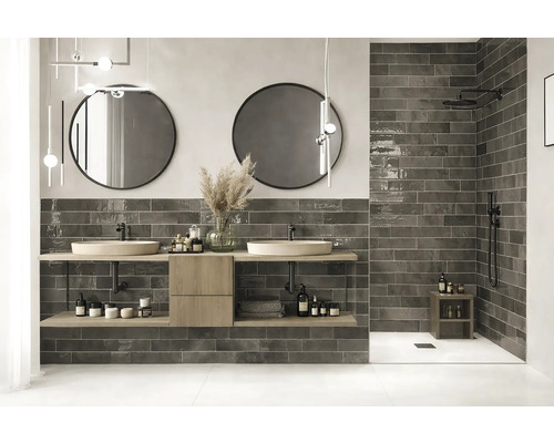 Moderná kúpeľňa s dvojitým umývadlom, okrúhlymi zrkadlami a tmavými obkladmi