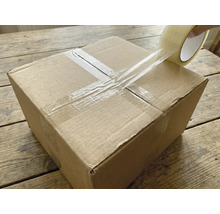 Kartónová krabica sa uzatvára priehľadnou lepiacou páskou.