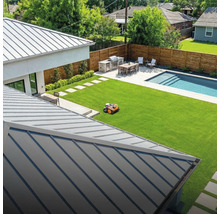 Pohľad na záhradu s robotickou kosačkou, grilom, jedálenským stolom a bazénom.