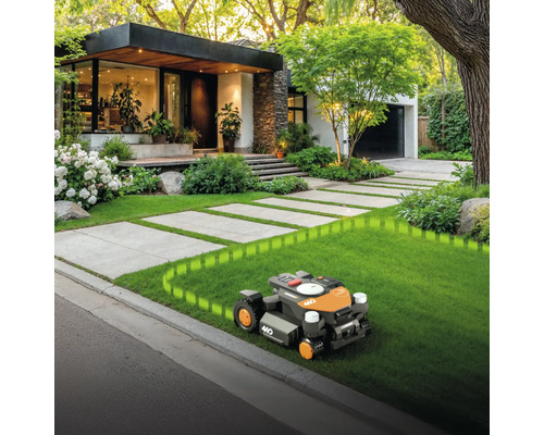 Robotická kosačka v prevádzke pred moderným domom s upravenou záhradou