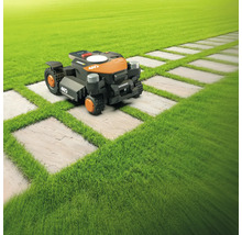 Robotická kosačka na trávniku s chodníkom z kamenných dosiek