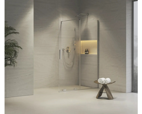 Sprchovací kút so sklenenými dverami, armatúrou a úložným priestorom vo svetlej kúpeľni