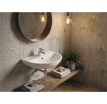 Kúpeľňa s umývadlom, zrkadlom a dekoratívnymi prvkami na drevenej polici.