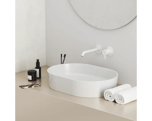 Moderná kúpeľňa s umývadlom na dosku, vodovodnou batériou a uterákmi