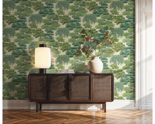 Obývacia izba s tapetou so vzorom stromov, drevenou komodou, stolnou lampou a vázou
