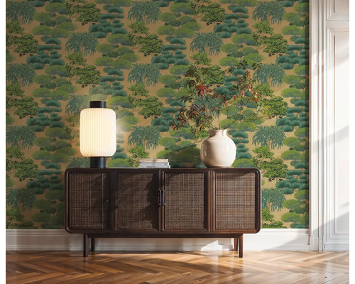 Dekoratívna zelená tapeta so vzorom stromov za drevenou skriňou v miestnosti.