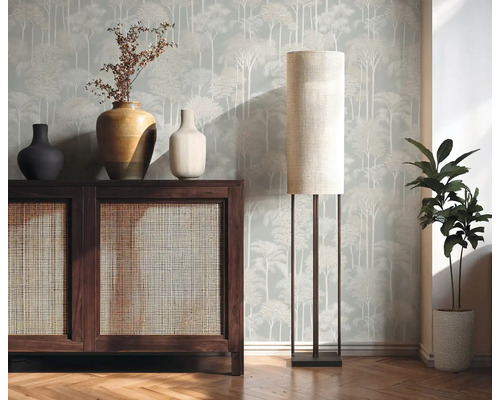 Interiérový pohľad s drevenou komodou, stolnou lampou a izbovou rastlinou pred vzorovanou tapetou