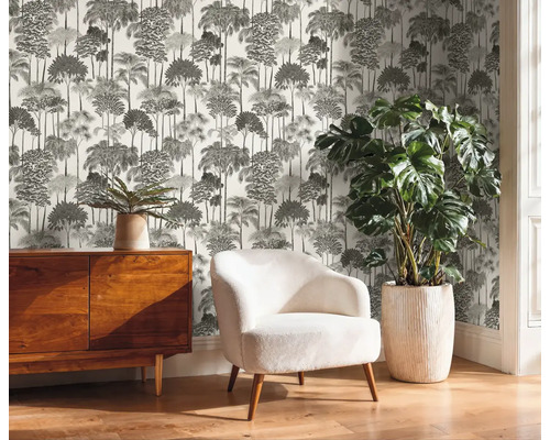 Pohľad na miestnosť s komodou, kreslom, izbovou rastlinou a tlačenou tapetou so vzorom stromu