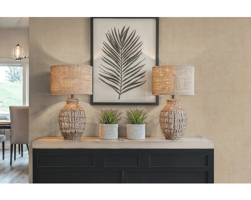 Dekoratívna scéna s dvoma stolnými lampami, rastlinami a zarámovanou potlačou listov na príborníku