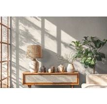 Svetlá obývacia izba s konzolovým stolíkom, lampou, vázami a izbovou rastlinou