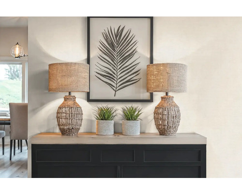 Dekoratívna scéna s dvoma stolnými lampami, dvoma rastlinami v kvetináčoch a zarámovanou potlačou listov na skrinke