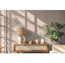 Obývacia izba s dreveným stolom, lampou, vázami a rastlinou pred stenou