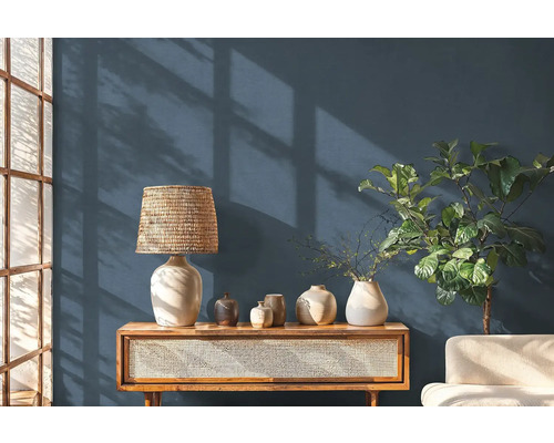 Obývacia izba s drevenou konzolou, stolnou lampou a dekoratívnymi predmetmi.