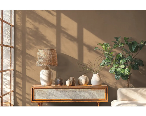 Obývacia izba s dreveným stolom, lampou, rôznymi vázami a izbovou rastlinou