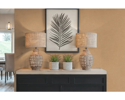 Dekoratívna scéna s dvoma lampami, rastlinami a zarámovaným obrázkom listu na skrinke