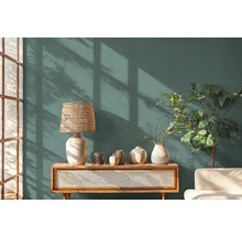 Obývacia izba s komodou, lampou, vázami a izbovou rastlinou pred stenou