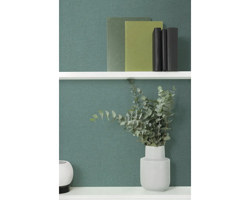 Polica s knihami a eukalyptom vo váze