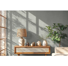 Obývacia izba so stolnou lampou, dekoráciou a rastlinou na drevenej skrini.