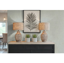 Dekoratívny interiér s dvoma stolnými lampami, umelými rastlinami a zarámovanou potlačou listov na komode.