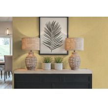 Dekoratívny interiér s dvoma stolnými lampami, rastlinami a zarámovanou potlačou listov na príborníku