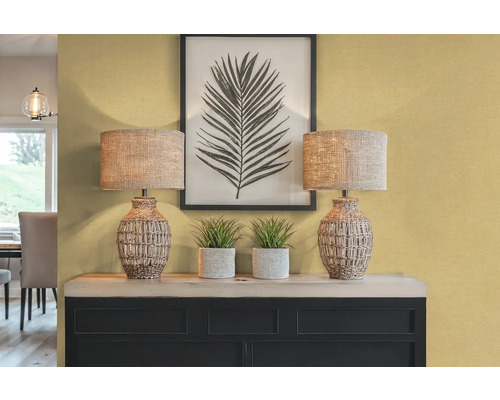 Dekoratívny interiér s dvoma stolnými lampami, rastlinami a zarámovanou potlačou listov na príborníku