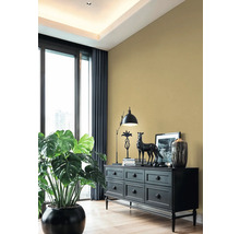 Obývacia izba s čiernou komodou, lampou, dekoráciou a izbovou rastlinou