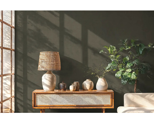 Dekoratívna scéna s lampou, vázami, komodou a izbovou rastlinou pred stenou