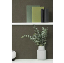 Polica s knihami a váza s eukalyptom