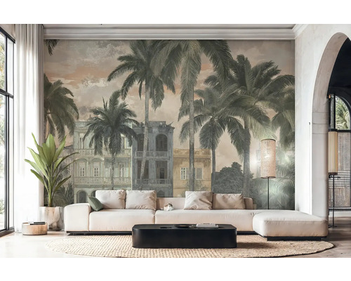 Svetlá obývacia izba s fototapetou vo vintage štýle s palmami a koloniálnymi budovami. Biela rohová pohovka, čierny konferenčný stolík a koberec.