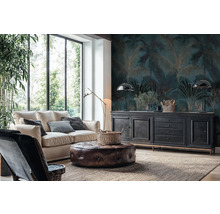 Obývacia izba s fototapetou s motívom paliem v tmavomodrej a zlatej farbe, svetlou pohovkou, koženým taburetom a čiernou komodou pri veľkých oknách.