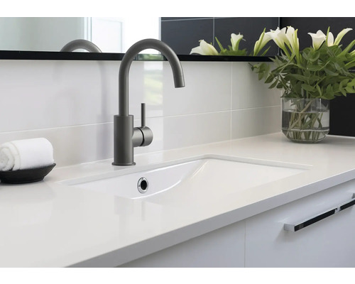 Kúpeľňové umývadlo s batériou, uterákom a vázou s kvetinami