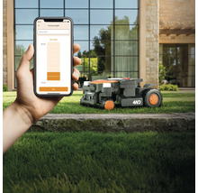 Robotická kosačka v prevádzke, ovládaná pomocou aplikácie pre inteligentné telefóny na nastavenie výšky kosenia
