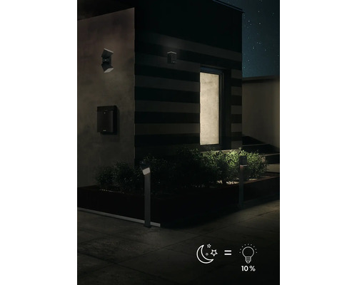 Vonkajší pohľad na dom s záhradným osvetlením a nástennými svietidlami v noci