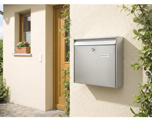 Nerezová poštová schránka na stene domu vedľa dverí