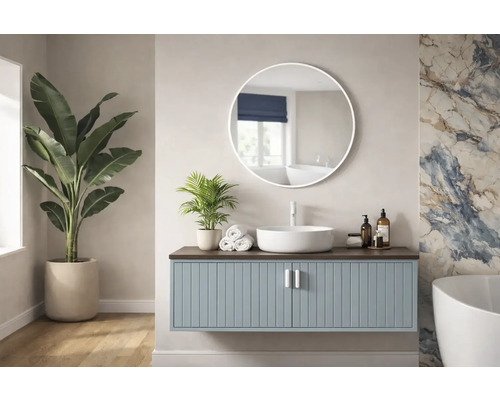 Svetlá kúpeľňa s umývadlovou skrinkou, okrúhlym zrkadlom a izbovými rastlinami.