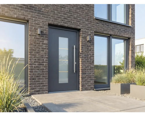 Moderný dom s vchodovými dverami so sklenenou vložkou, tehlovou fasádou a veľkými oknami