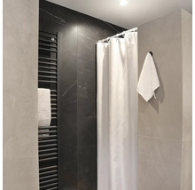Moderná kúpeľňa so sprchovacím závesom, rebríkovým radiátorom a uterákom