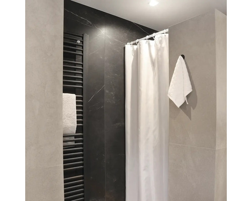 Moderná kúpeľňa so sprchovacím závesom, rebríkovým radiátorom a uterákom