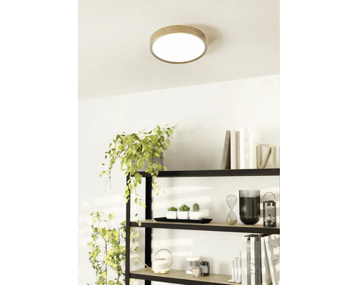 Stropné svietidlo s dreveným okrajom v svetlej miestnosti nad policou.