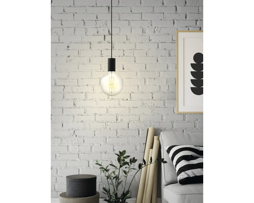 Závesná lampa s Edisonovou žiarovkou pred tehlovou stenou