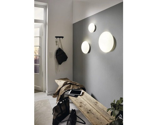 Svetlý vstupný priestor s drevenou stoličkou, nástennými svietidlami a vešiakom