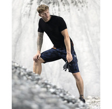 Muž má na sebe krátke pracovné nohavice s maskovacím vzorom, tričko a rukavice