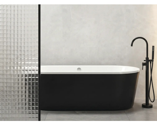 Voľne stojaca vaňa s čiernym exteriérom a bielym interiérom vedľa armatúry v kúpeľni.
