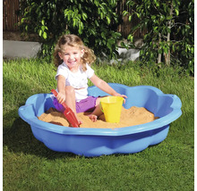 Dieťa sa hrá v modrom pieskovisku s hračkami do piesku v záhrade