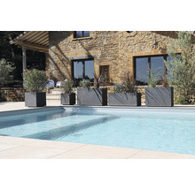 Rad kvetináčov rôznych veľkostí vedľa bazéna v záhrade.