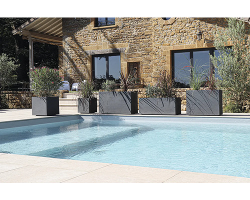 Rad kvetináčov rôznych veľkostí vedľa bazéna v záhrade.